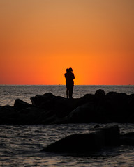 The romantic scene of the pair at sunset on the seashore