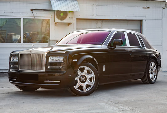 Front View Of New A Very Expensive Luxury Rolls Royce Phantom Car, A Long Black Limousine, Model Outdoors, Prepared For Sale With Shining Sunlight