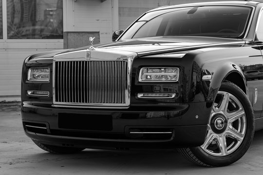 Front View Of New A Very Expensive Luxury Rolls Royce Phantom Car, A Long Black Limousine, Model Outdoors, Prepared For Sale With Shining Sunlight