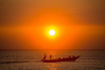 Colorful golden Sunset on Sea. Fishermans are returning home with fish, manually at sunset on Char Samarj beach at Chandpur, Bangladesh.