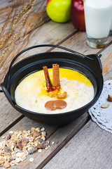 Traditional breakfast. Milk oatmeal with chocolate and granola. on a wooden table.