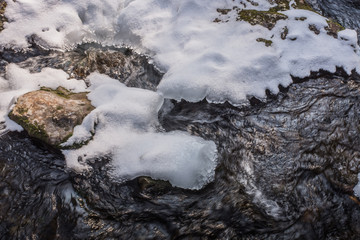 wirbelndes wasser in einem bach mit schnee