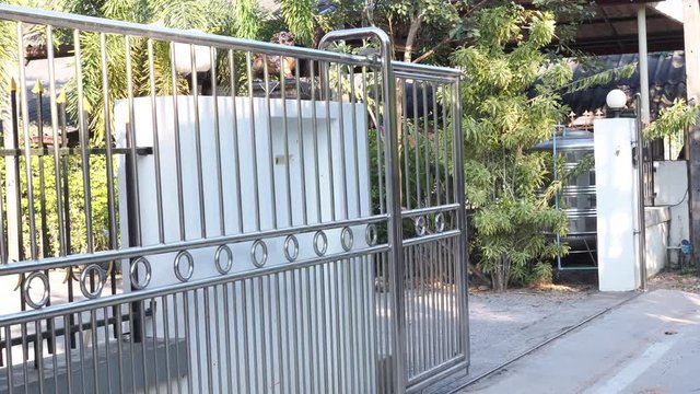 Automatic stainless steel fence gates are opening and closing.