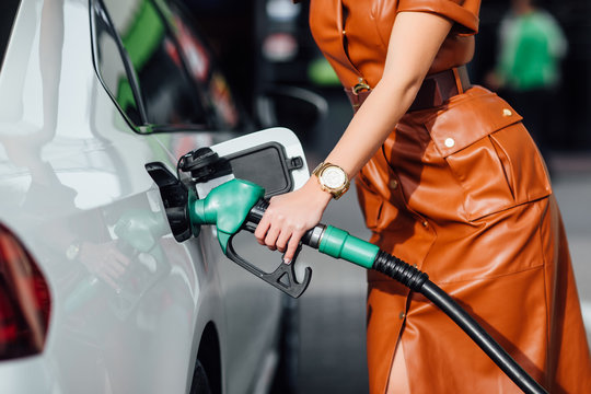 Hand refilling the car with fuel.