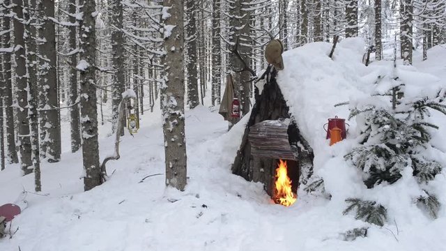 Wooden hut with bonfire in winter
