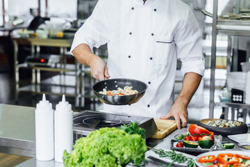 Close up photo, handsome young man with apron frying vegetables for pasta, tasty food concept.