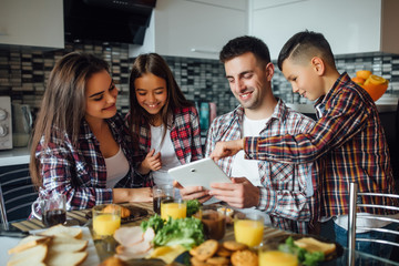 Family using digital devices at breakfast table, lovely concept and happy person.