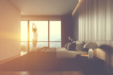 Woman in white and wooden master bedroom