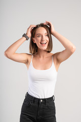 Obraz na płótnie Canvas Smiling young woman touching her hair