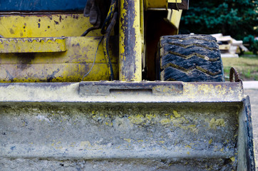 view of the dirty bucket of a yellow scratched construction bulldozer. construction work concept. mining background