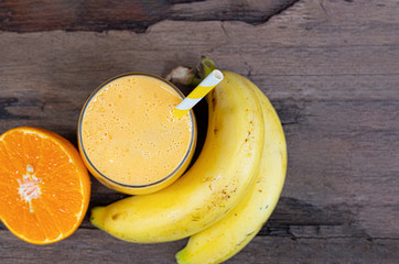 Banana and orange smoothies yellow colorful fruit juice milkshake blend beverage healthy high protein the taste yummy In glass,drink to lose weight drink episode on wooden background.