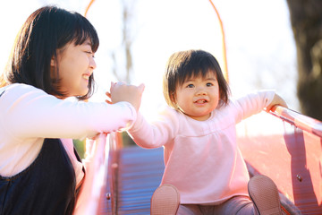 すべり台で遊ぶ親子