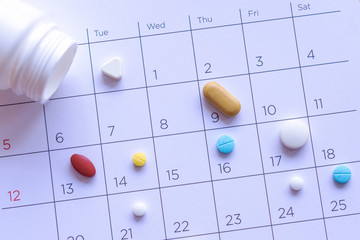 bunch of different pills on a calendar background. concept Healthcare