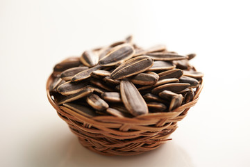 Sunflower seeds in basket on white background 