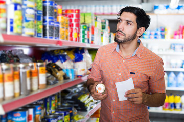 man is choosing Oregano with help note list