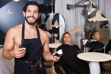 smiling man hairdresser and woman in salon