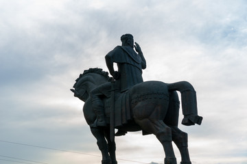 Tbilisi, Georgia, JULY, 2019: Stone equestrian statue rider with sword and raised hand on the river Bank