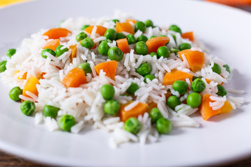 Basmati rice with carrots and green peas. Close up view.