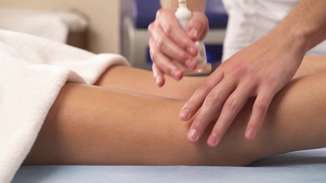 Close-up of the female patient receiving hips and legs vacuum anti-cellulite massage at spa. Anti-cellulite program for health and slimming
