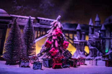 Miniature of winter scene with Christmas houses, train station, trees, covered in snow. Nights scene. New year or Christmas concept. Selective focus