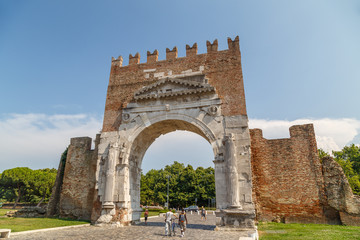 Fototapeta na wymiar RIMINI / ITALY - JULY 2015: Roman triumphal arch converted into medieval gate in Rimini, Italy
