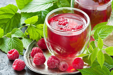 Berry juice in glass with fresh raspberries