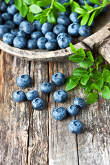 Blueberries with leaves on  old wooden table