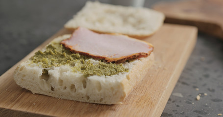 making sandwich with pesto and smoked pork
