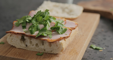 making sandwich with pesto, smoked pork and spinach
