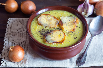 Onion soup with ingredients onions, cheese, toasts, dark wooden background