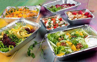 A set of diet dishes in containers on a colored wooden background. Takeaway. Diet and healthy food.