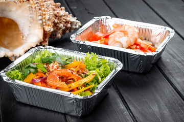 A set of diet dishes in containers on a dark wooden background. Takeaway. Diet and healthy food.