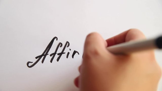 Hand writing Affirmation on white paper