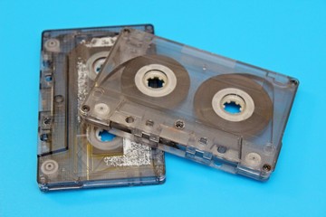 Plastic transparent audio cassettes located on a blue background