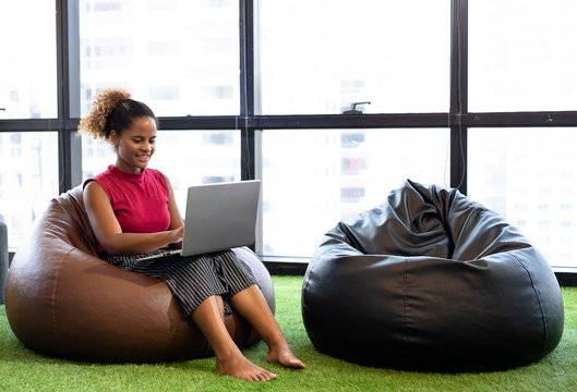 Business team man and woman using digital tablets while relaxing on beanbag