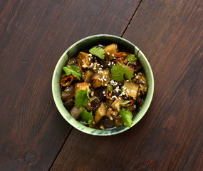 Fried eggplant with garlic, cilantro in ginger and soy sauce, top view, copy space