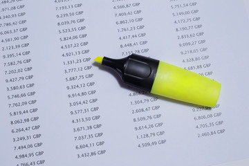 Financial spreadsheet on United Kingdom pounds, showing amounts of money with a yellow marker.