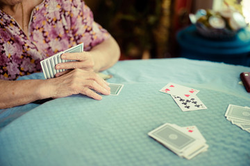Obraz premium Portrait of seniors elderly old woman playing card game at lunch table at home.brain exercise with card game and alzheimer concept.