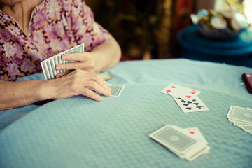 Portrait of seniors elderly old woman playing card game at lunch table at home.brain exercise with card game and alzheimer concept.