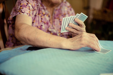 Portrait of seniors elderly old woman playing card game at lunch table at home.brain exercise with card game and alzheimer concept.