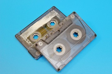 Plastic transparent audio cassettes located on a blue background