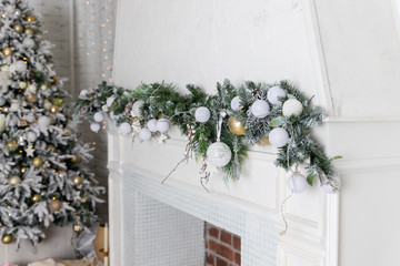 Christmas decoration with fireplace in the living room.Christmas garland on white fireplace. Decor...