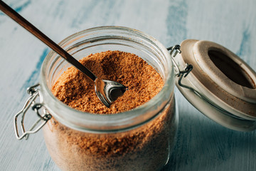 Close up view of raw cane sugar in a jar. Panela brown sugar background.. 