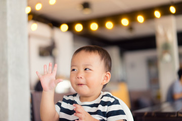 Baby boy make delicious face when he eat yummy food in restaurant.Enjoying delicious face.