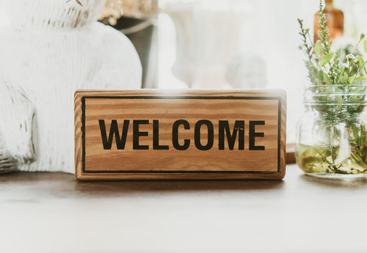 Welcome sign on wooden with black letters printed on soft pine putting guests at the shop.film tone.