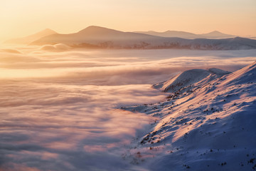 Fototapeta na wymiar Landscape with high mountains, morning fog and beautiful sunrise. Orange sky. Winter scenery. Wallpaper background. Location place Carpathian, Ukraine, Europe.
