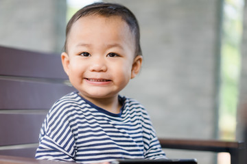 Happy Asian boy child looking cartoon in smart phone.child, technology and internet concept