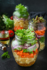 Fototapeta na wymiar healthy salad in a jar (vegetable snack pasta salad) menu concept. food background. top view. copy space
