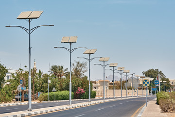 Street lamp powered with a solar panel battery against blue sky.  Alternative energy and save...