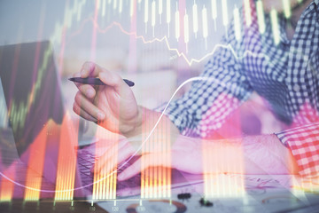 Double exposure of forex graph with man working on computer on background. Concept of market analysis.